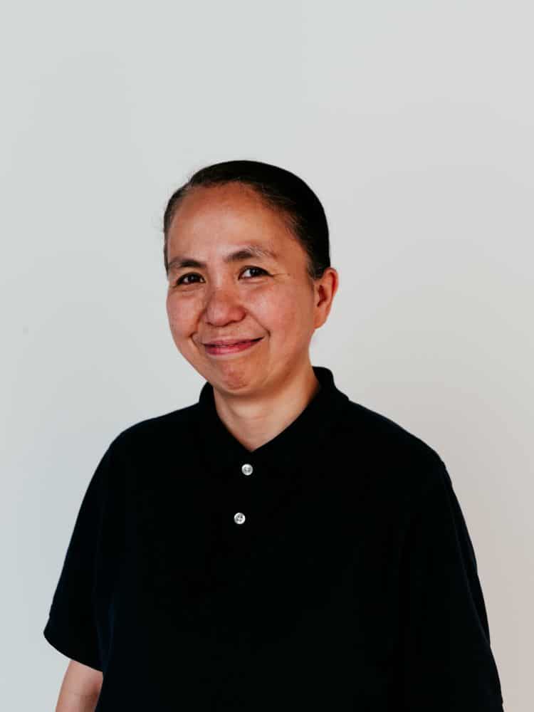 A woman with short hair wearing a buttoned up polo shirt.