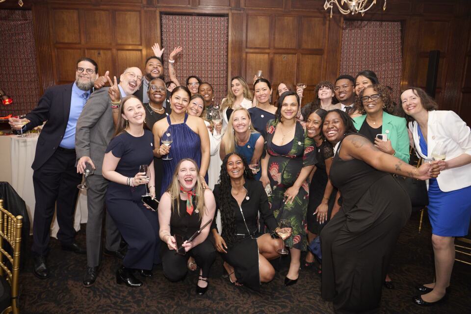 A group of happy people celebrating at a festive event, smiling for the camera.